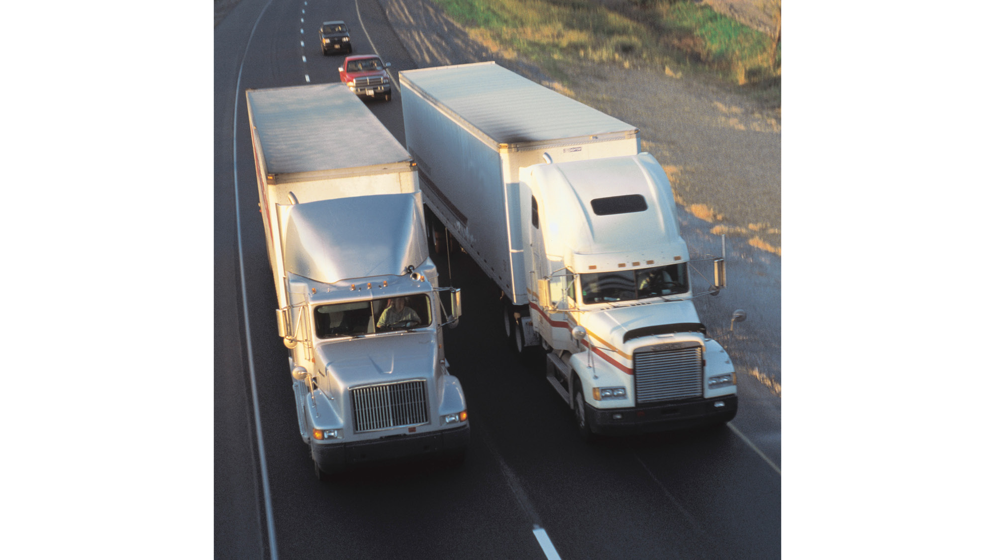 One truck slowly passing another causing traffic to bunch behind